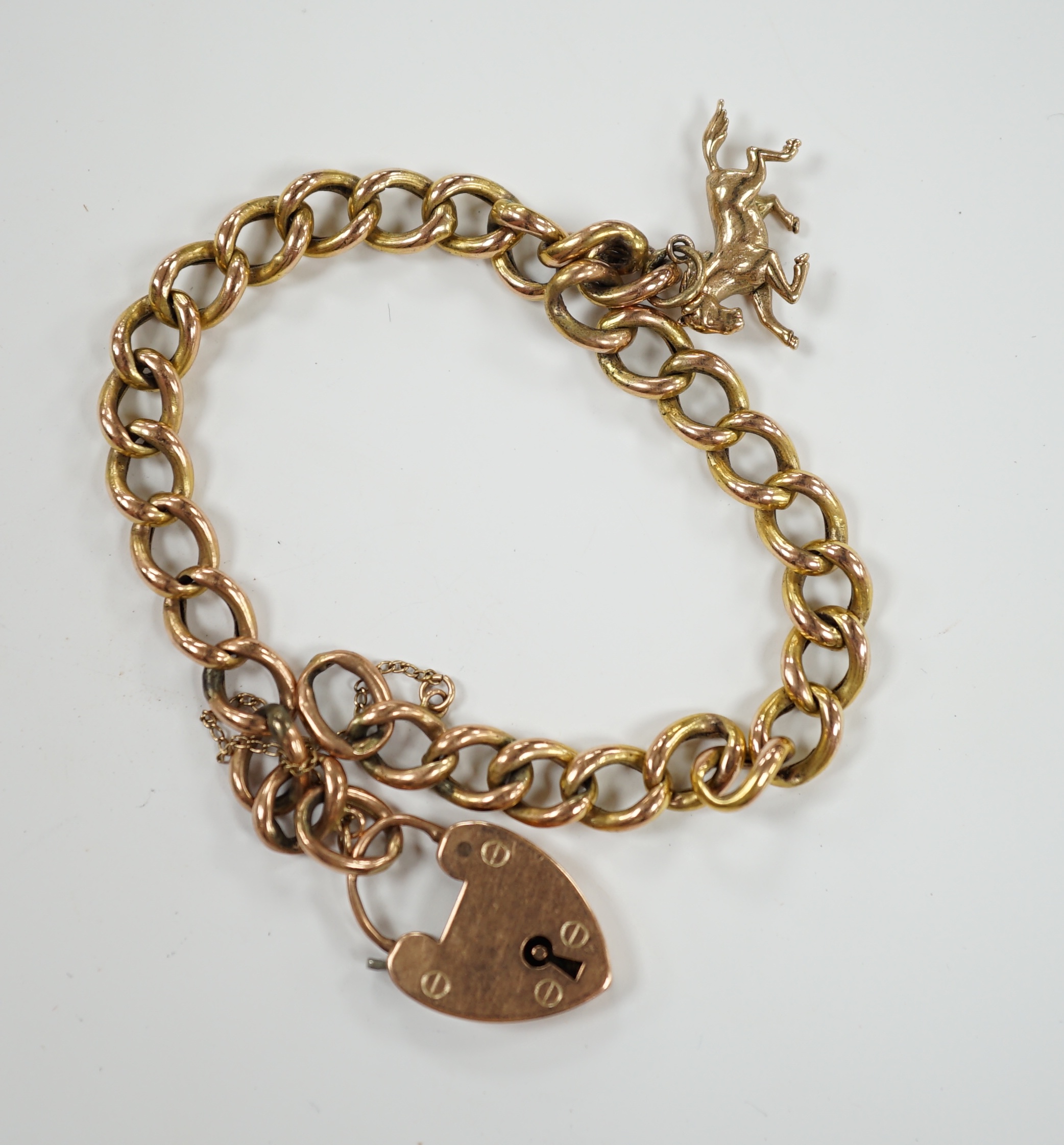 A yellow metal (stamped 9c) curb link bracelet, with heart shaped padlock clasp, hung with a 9ct gold horse charm, 13.9 grams.